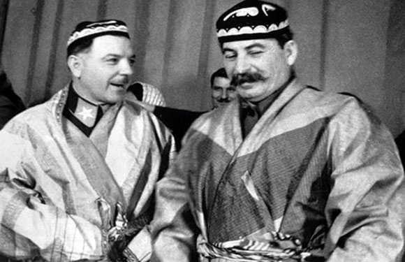 Two men wearing traditional Caucasian attire smiling and posing for a photo.