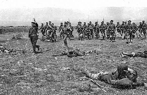 Historical B&W photo shows soldiers in a field, possibly from a battle or military exercise.