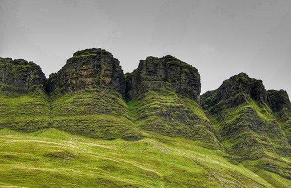 An image of a rugged, green mountainous landscape with overcast skies.