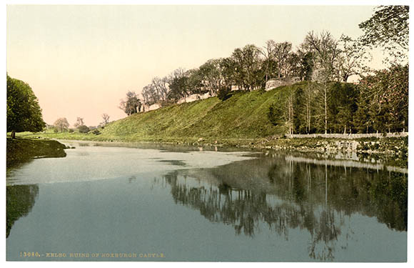 A vintage postcard depicting a tranquil river scene with trees and a grassy embankment under a clear sky.