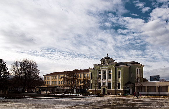 A photo depicts a classic building with a dome, set against a cloudy sky in a snowy, winter landscape.