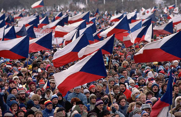 A large crowd of people with many holding the Czech flag.