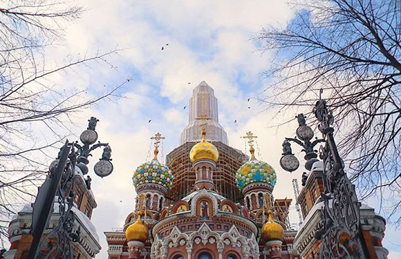 A photo shows the colorful, detailed Church of the Savior on Spilled Blood in Saint Petersburg, Russia, under a cloudy sky.