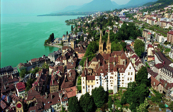 Aerial view of a coastal town with historical architecture near a large body of water.