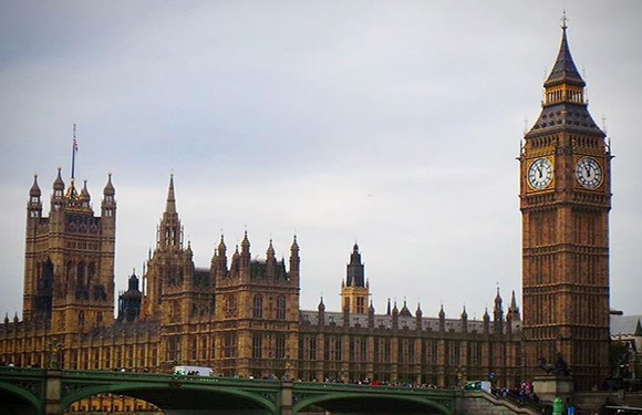 A photo features the Elizabeth Tower (Big Ben) and the Houses of Parliament in London, with a bridge and overcast sky.