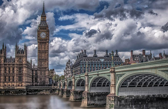 A photo captures Big Ben and the Houses of Parliament in London, with Westminster Bridge under a partly cloudy sky.