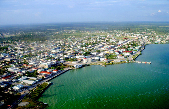 Aerial view of a coastal town with buildings and streets adjacent to a body of water.