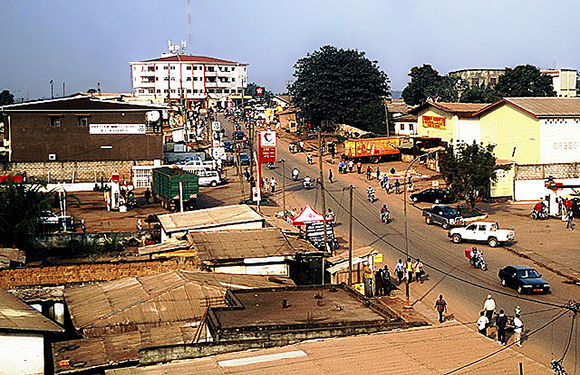 A bustling street scene in an urban area with buildings, cars, and pedestrians.