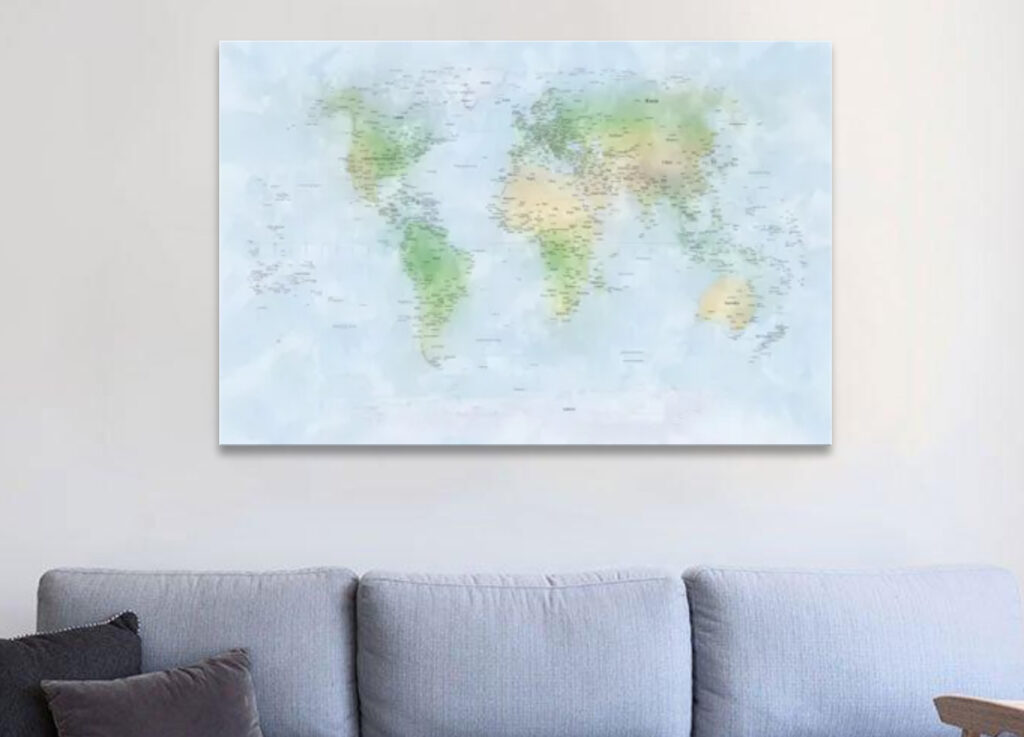 A canvas world map hanging above a grey sofa with cushions.