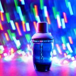 A colorful image featuring a bottle with the label "H2O" in the center, set against a vibrant background with blurred multicolored lights.