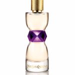 A perfume bottle with a clear glass top, a purple faceted center, and a white label with gold text.