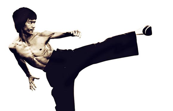 A person performing a high kick against a plain background.