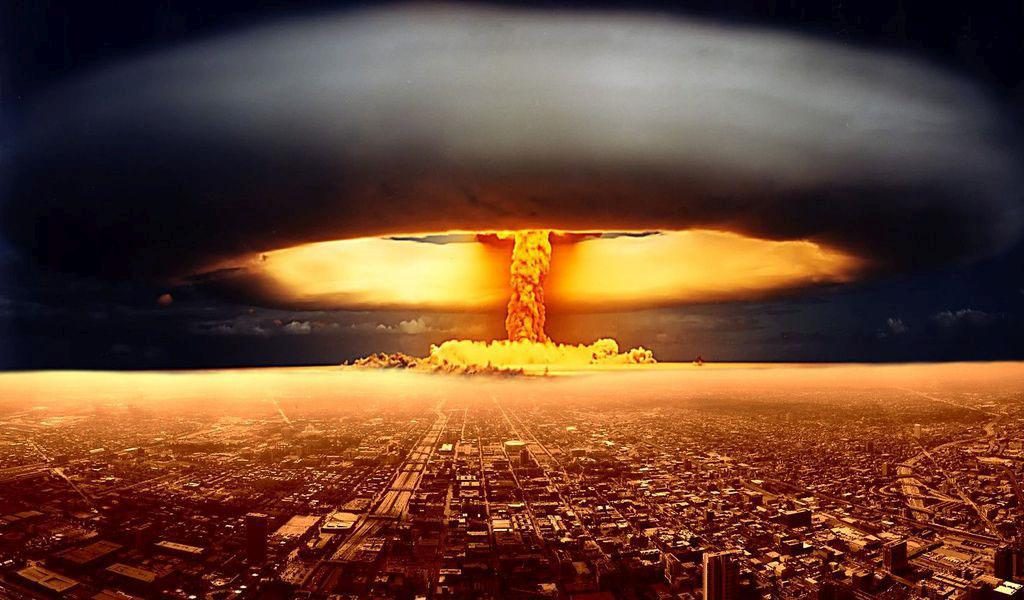 An image depicting a large mushroom cloud from a nuclear explosion rising above a cityscape during sunset or sunrise.