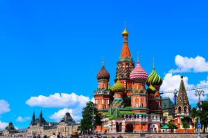 A colorful cathedral with onion domes against a blue sky with clouds.