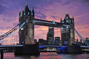 A photograph of Tower Bridge in London during twilight with a pink and purple sky in the background.