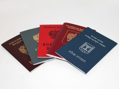 A collection of passports from different countries spread out on a white surface.