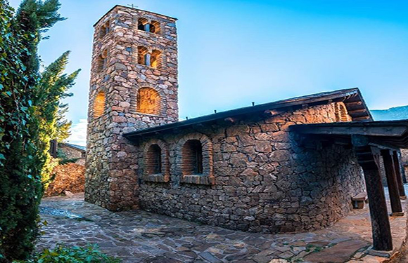 A stone building with a tower against a blue sky.