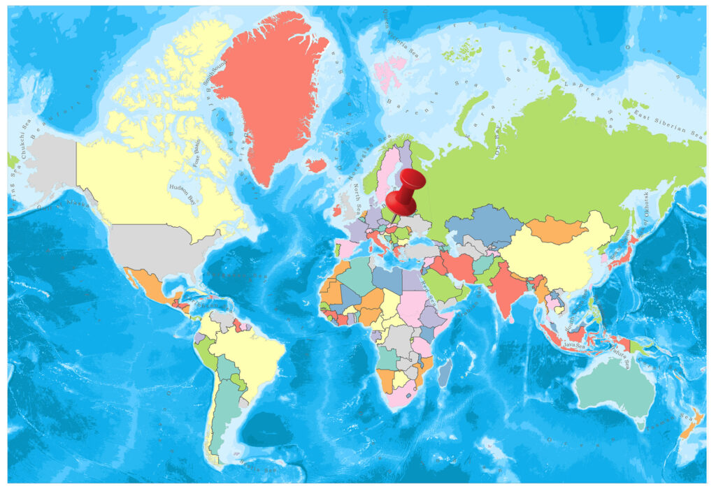 A colorful world map with countries in different colors against a blue ocean background, with a red pin marking a specific location on the map.