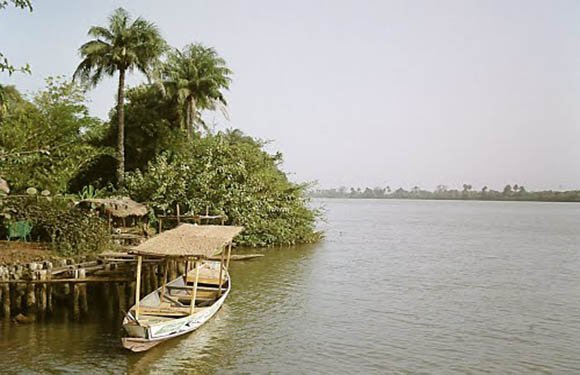 A view of the water surrounding Janjanbureh Island and a small boat.