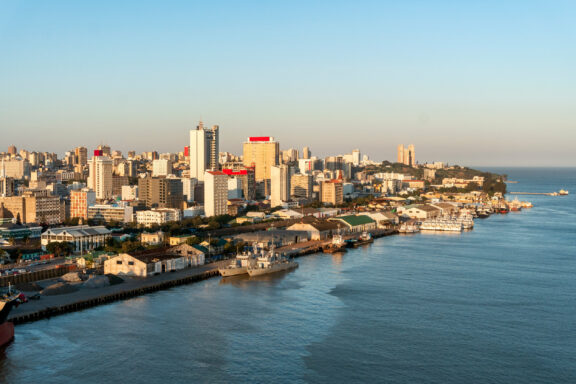 Aerial view of a coastal city skyline with high-rise buildings near a body of water during daylight.