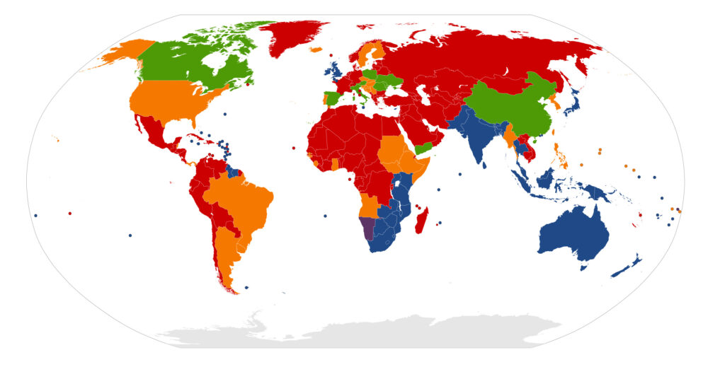 A low-resolution world map depicting countries color-coded by driving standards, indicating which side of the road traffic drives on.