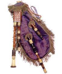 A traditional set of bagpipes with a purple fabric bag, ornate piping, and tassels.