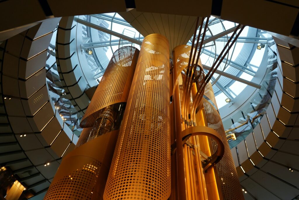 Interior of the Starbucks Roastery in Chicago featuring large copper casks and modern architectural design with glass ceiling.