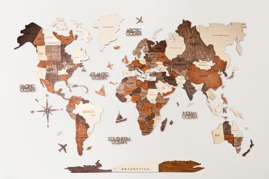 A wooden world map wall art featuring the continents in various shades of brown, mounted on a white background.