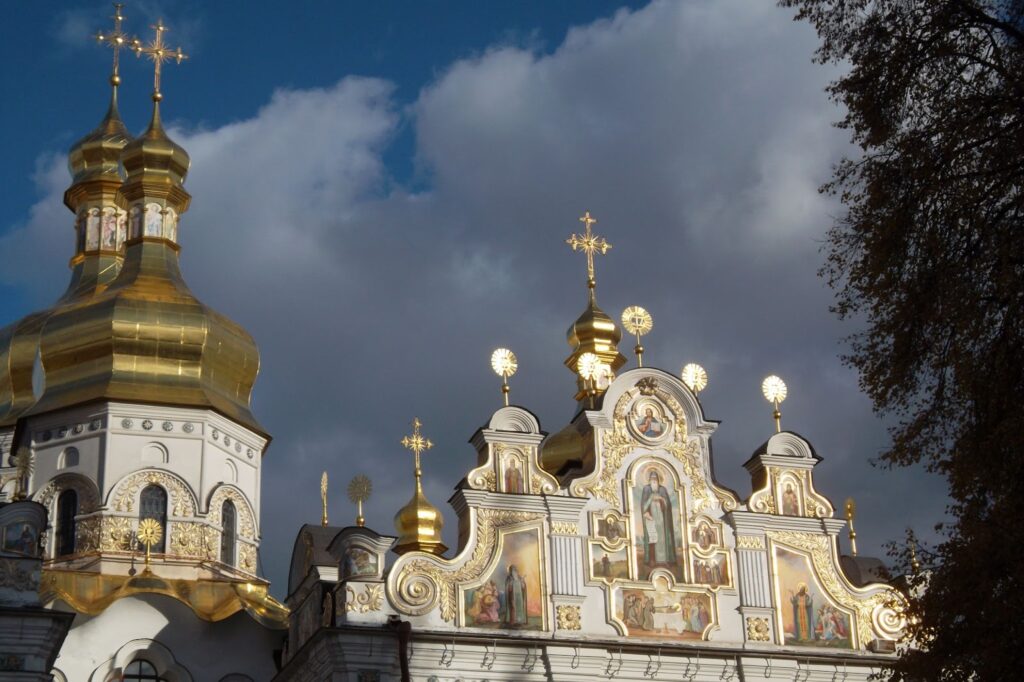 Golden domes and crosses of Kyiv Pechersk Lavra against a cloudy sky.