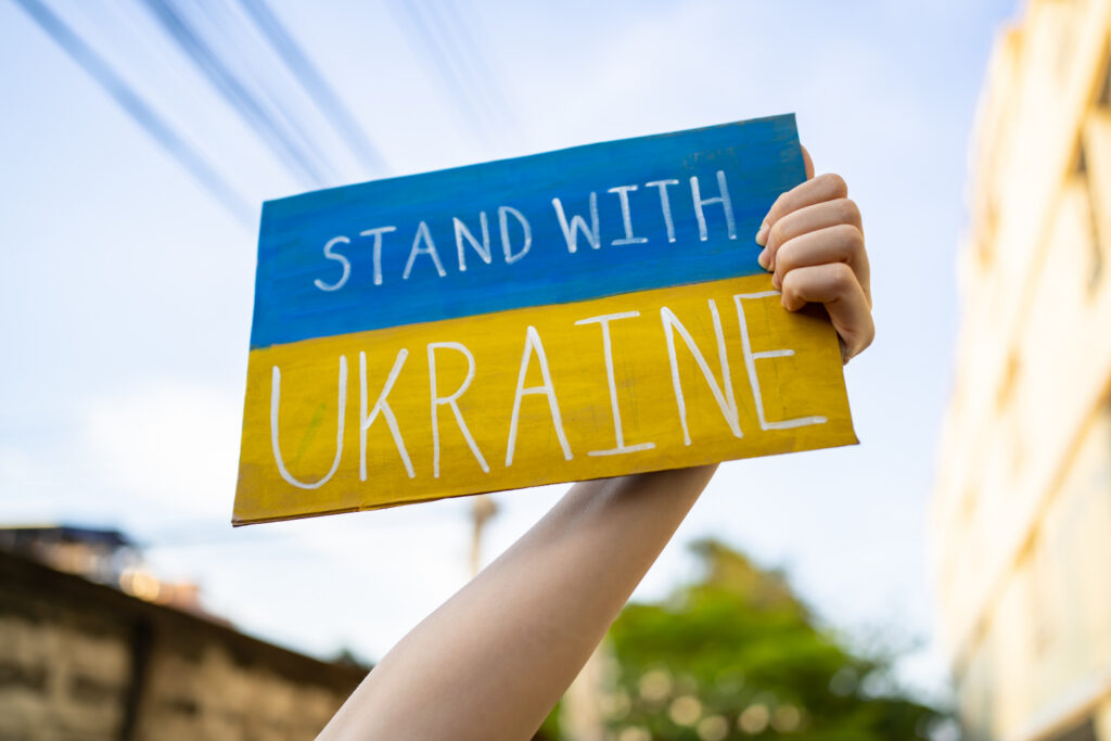 Demonstrator holding "Stand with Ukraine"