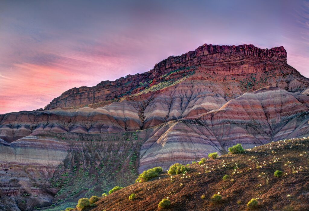 A multicolored rock formation under a sunset sky in Utah.
