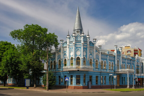 A blue and white ornate building with a spire, resembling a castle, under a partly cloudy sky, possibly located in the Cherkasy Oblast area.