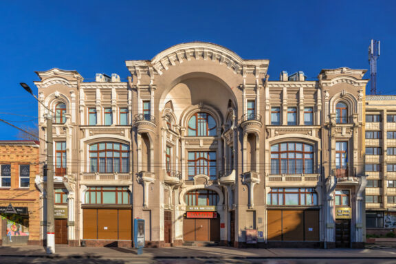 The Kropyvnytskyi Art Museum has an ornate facade with arched windows and intricate details, under a clear sky.