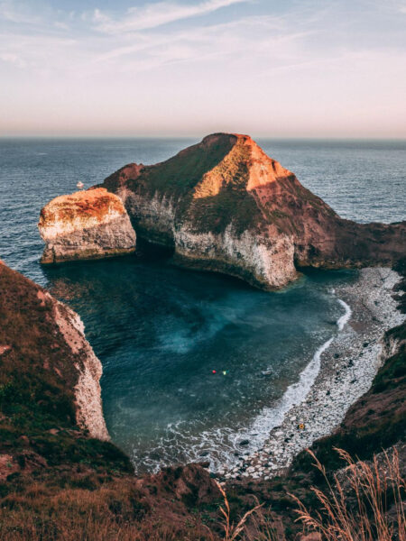 A scenic view of the Flamborough Headland with chalk cliffs and a calm sea at sunset near Bridlington, UK.