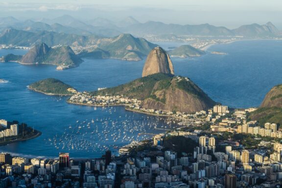 Aerial view of Rio de Janeiro, Brazil, showcasing the cityscape, Sugarloaf Mountain, and surrounding waters.