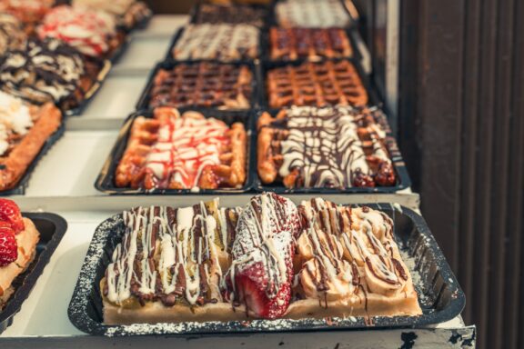 A selection of Belgian waffles with various toppings displayed in Brussels.