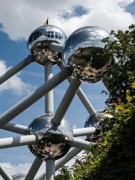 A photo shows the Atomium in Brussels, with large spheres linked by tubes, against a partly cloudy sky.