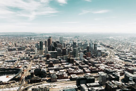 Aerial view of downtown Denver, Colorado, with skyscrapers and buildings under a clear sky.