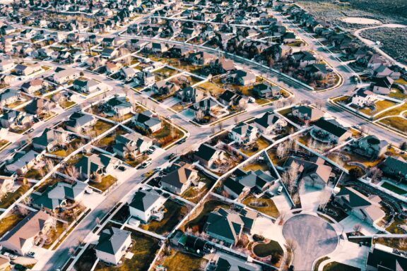 Aerial shot of a densely packed residential area in Herriman, Utah, with diverse roof colors and landscaped yards.