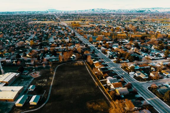 Aerial view of a residential area in Meridian, Idaho, showing rows of houses with autumn-colored trees and a clear road network.