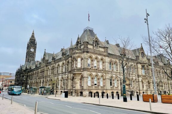 A street view in Middlesbrough showing a historic building with a clock tower, under a cloudy sky.