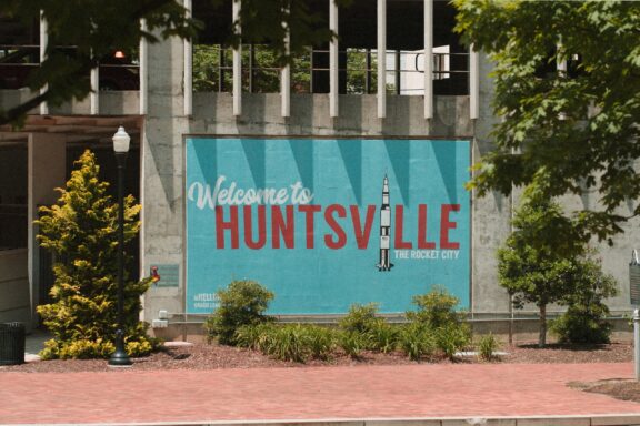 A mural saying "Welcome to HUNTSVILLE" with a rocket image is displayed in Huntsville, Alabama.