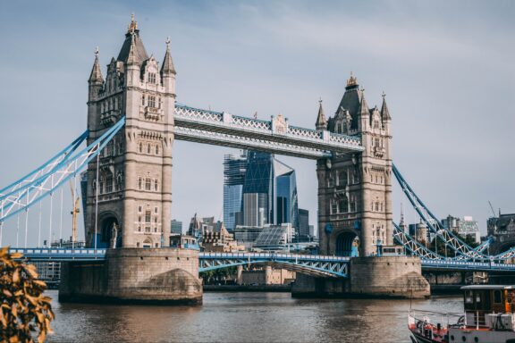 A photo of London's Tower Bridge over the Thames, with the city skyline behind it.