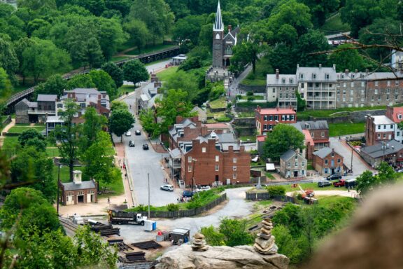 Aerial view of a small town in West Virginia with traditional buildings, a church spire, and greenery surrounding the area.