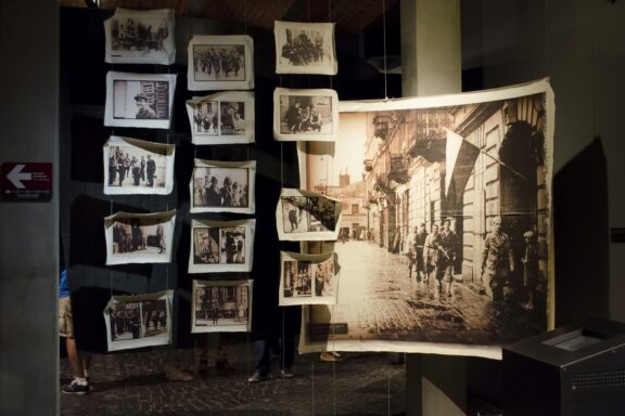 The Warsaw Uprising Museum exhibits black and white photos from the event, with a large central image.