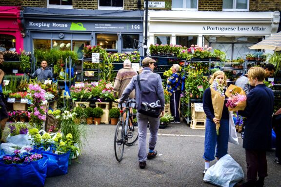 People browsing through various flower stalls at Columbia Flower Market.