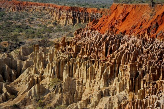 A view of the Moon viewpoint in Belas, Angola, showcasing the unique and rugged terrain with reddish-brown earth and jagged formations.