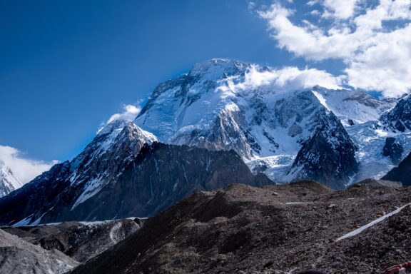 A view of Broad Peak, a mountain in the Karakoram range, with a clear blue sky and snow-covered summit.