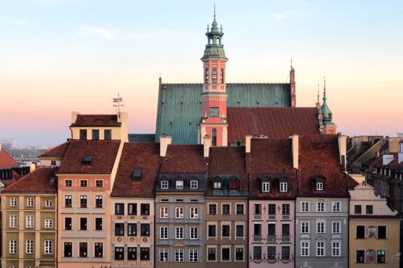 A view of historical buildings with colorful facades at dusk in Warsaw, Poland.