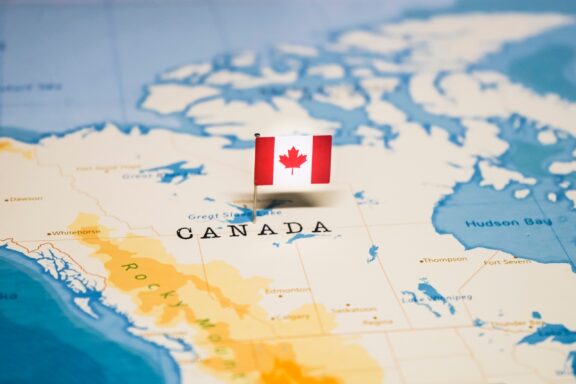 Map of Canada with Canadian Flag Pin Flag pin of Canada, pointing at its location in the North American continent